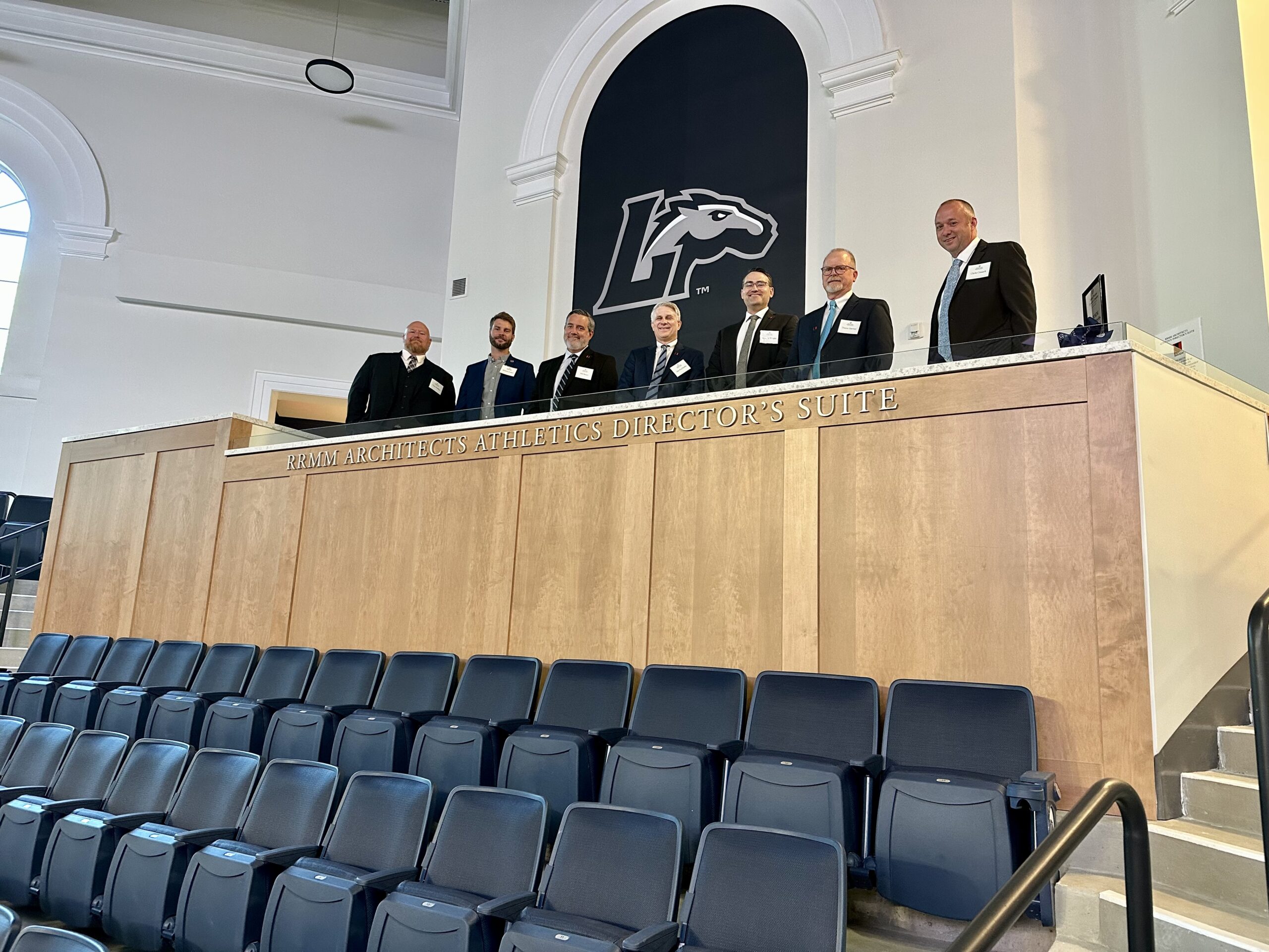 Leaders from RRMM pictured in the RRMM Architects Athletics Director's Suite in the Joan Perry Brock Center